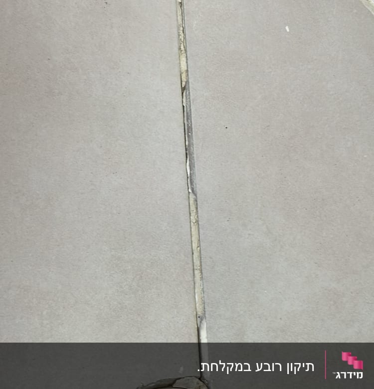 רצפת אריחים עם רובה פגומה סביב ניקוז